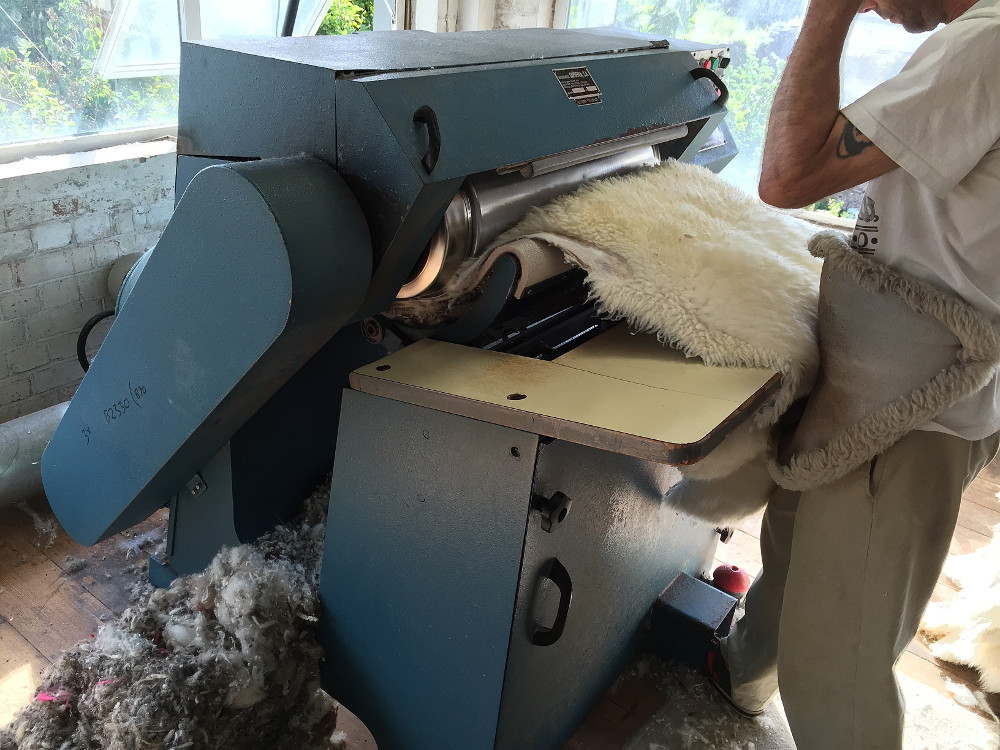 sheepskin rugs being ironed in a press