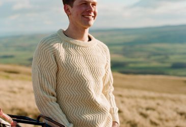 Man in field wearing a chunky zig zag ridged natural cream wool jumper