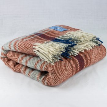 Red plaid chunky wool travel rug rolled up